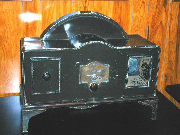 Figure 4 — A genuine, restored Baird Televisor (serial no. 717) at the Early Television Museum — the black tinplate case, the Nipkow disc visible edge-on above the cabinet, and the twin control knobs (speed a…